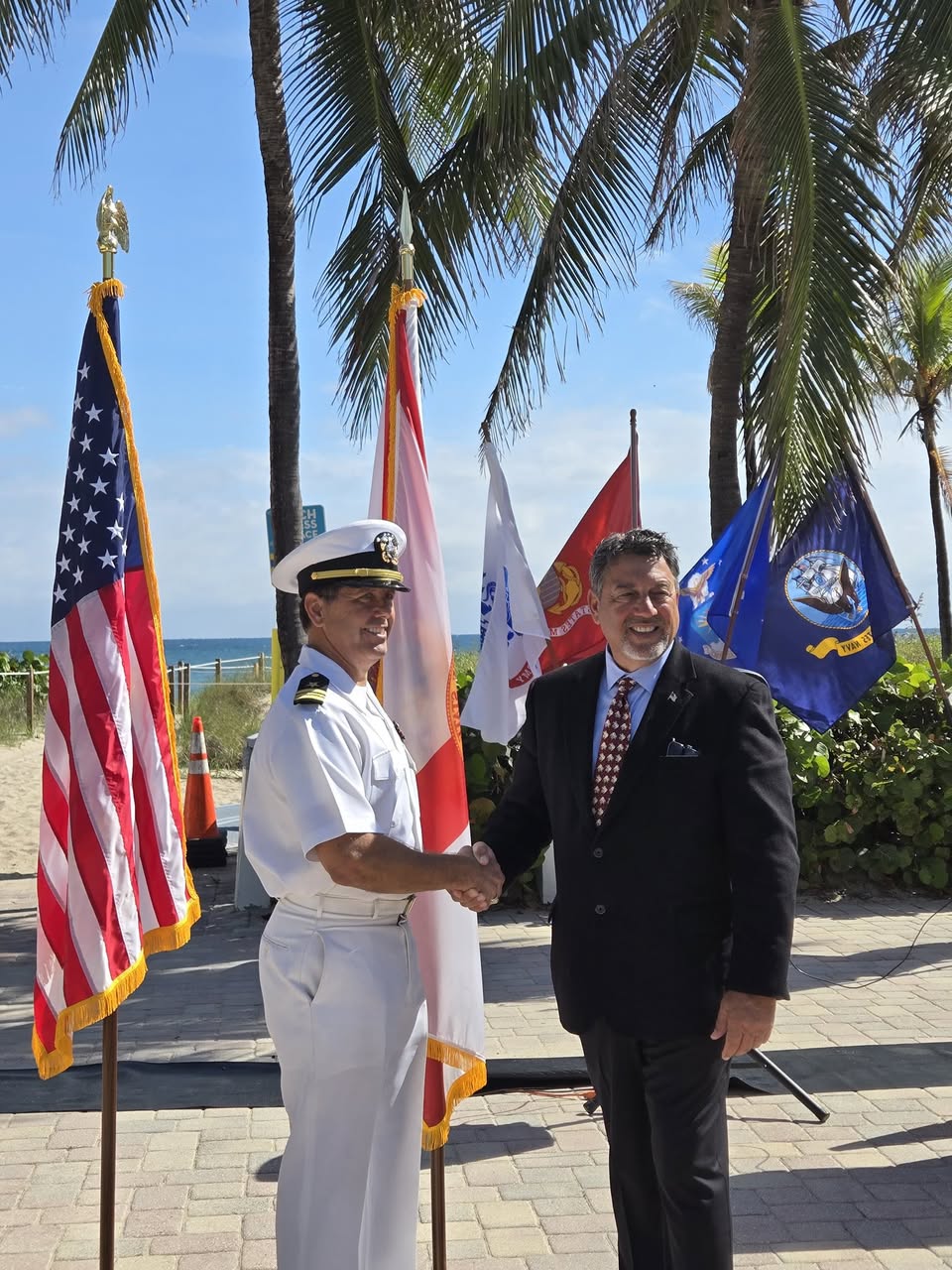 Randy Strauss shaking hands with a Navy officer at a Lauderdale-by-the-Sea civic ceremony.